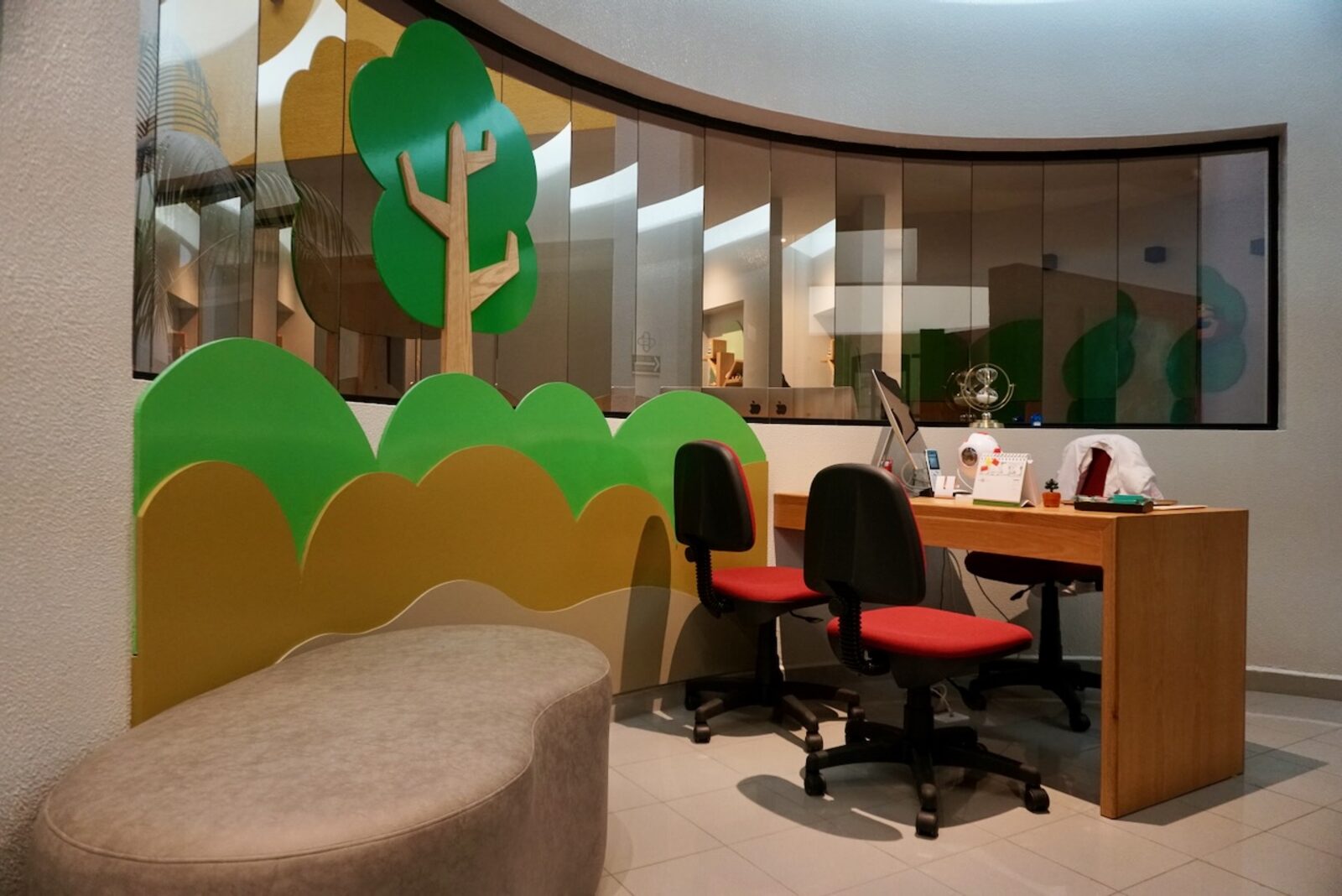 Reception of the pediatric ophthalmology office with forest mural and child-friendly furniture