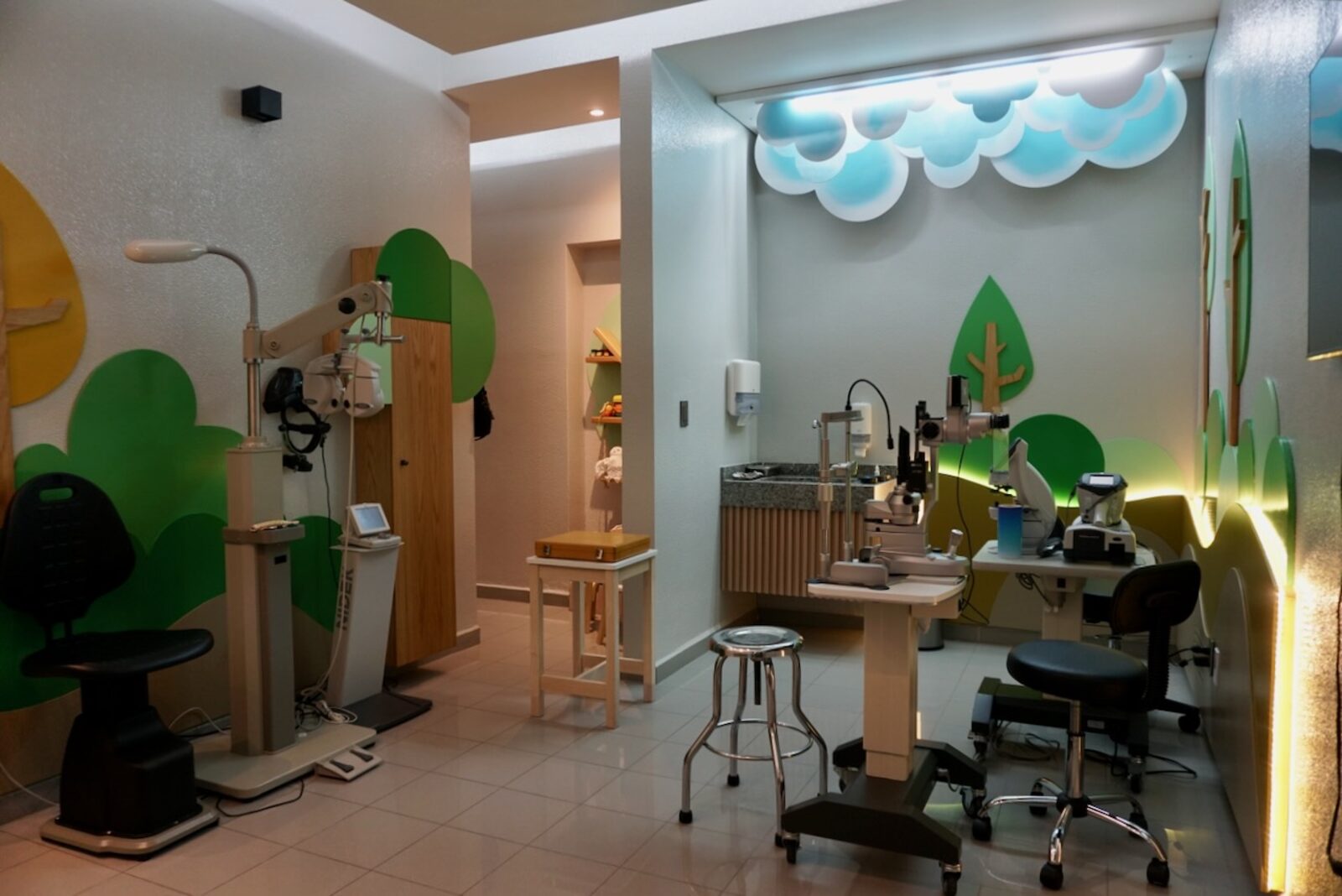 Pediatric examination room with illuminated clouds, refraction unit, and slit lamp